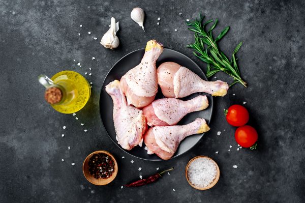 raw-chicken-legs-with-spices-stone-background
