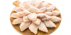 Raw chicken meat and wing on wooden cutting board or plate