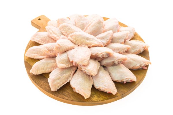 Raw chicken meat and wing on wooden cutting board or plate