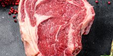 Raw cowboy steak or ribeye on the bone with herbs. Marble beef.