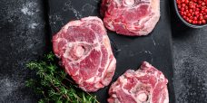 Raw lamb neck meat on a marble board.Black background. Top view