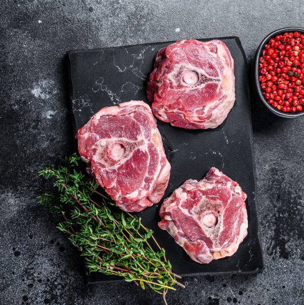 Raw lamb neck meat on a marble board.Black background. Top view