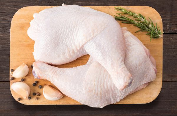 Set raw chicken on cutting board on the wooden background