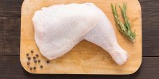 Set raw chicken on cutting board on the wooden background