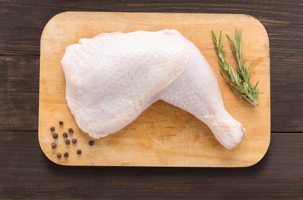 Set raw chicken on cutting board on the wooden background